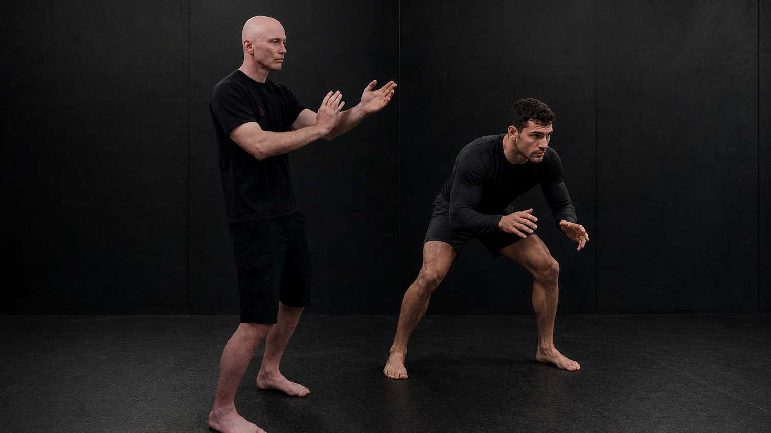 BJJ Grappler or wrestler and a Functional Wing Chun fighter in ready pose.