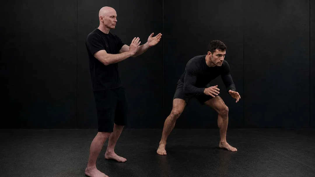 BJJ Grappler or wrestler and a Functional Wing Chun fighter in ready pose.